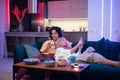 Happy young couple playing a video game sitting at home on a sofa during self isolation on quarantine. Royalty Free Stock Photo