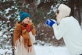 happy young couple playing on winter walk, throwing snowballs and having fun outdoor