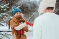 Happy young couple playing on winter walk, throwing snowballs and having fun outdoor