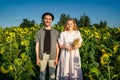 A happy young couple poses for a camera in a sunflower field Royalty Free Stock Photo