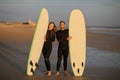 Happy Young Couple Posing With Their Surfboards On The Beach At Sunset Royalty Free Stock Photo