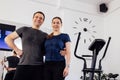 Happy young couple posing in wet shirts after ems workout. Man and woman are smiling and hugging in the gym or fitness club Royalty Free Stock Photo