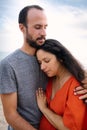 Happy young couple with pregnant woman smile and hug each other on a beach at sunset during summer. Expecting new family Royalty Free Stock Photo