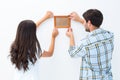 Happy young couple putting up picture frame Royalty Free Stock Photo