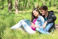 Happy young couple reading book in green park Royalty Free Stock Photo