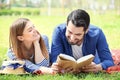 Happy young couple reading book in park on spring day Royalty Free Stock Photo