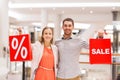 Happy young couple with red shopping bags in mall Royalty Free Stock Photo