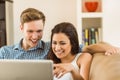 Happy young couple relaxing on the couch with laptop Royalty Free Stock Photo