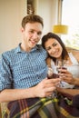 Happy young couple relaxing on the couch with red wine Royalty Free Stock Photo