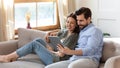 Happy young couple relaxing on couch, using computer tablet together Royalty Free Stock Photo