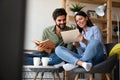 Happy young couple relaxing. Reading something on book and tablet computer. Royalty Free Stock Photo