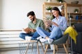 Happy young couple relaxing. Reading something on book and tablet computer. Royalty Free Stock Photo