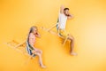 happy young couple resting in beach chairs on yellow, summer Royalty Free Stock Photo
