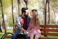 Happy young couple resting on bench in park Royalty Free Stock Photo