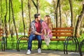 Happy young couple resting on bench in park Royalty Free Stock Photo