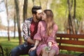 Happy young couple resting on bench in park Royalty Free Stock Photo