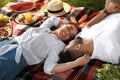 Happy young couple resting on picnic plaid outdoors Royalty Free Stock Photo