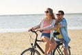 Happy young couple riding bicycle on beach Royalty Free Stock Photo