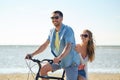 Happy young couple riding bicycle on beach Royalty Free Stock Photo