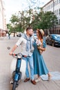 Happy young couple riding a scooter in the city on a sunny day Royalty Free Stock Photo