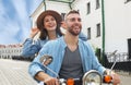 Happy young couple riding scooter in town. Handsome guy and young woman travel. Adventure and vacations concept. Royalty Free Stock Photo