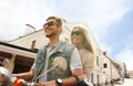 Happy young couple riding scooter in town. Handsome guy and young woman travel. Adventure and vacations concept. Royalty Free Stock Photo