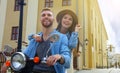 Happy young couple riding scooter in town. Handsome guy and young woman travel. Adventure and vacations concept. Royalty Free Stock Photo