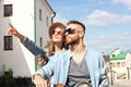 Happy young couple riding scooter in town. Handsome guy and young woman travel. Adventure and vacations concept. Royalty Free Stock Photo