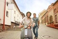 Happy young couple riding scooter in town. Handsome guy and young woman travel. Adventure and vacations concept. Royalty Free Stock Photo