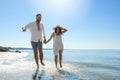 Happy couple running on beach near sea. Honeymoon trip Royalty Free Stock Photo