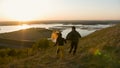 Happy young couple running on the hill holding hands at sunset Royalty Free Stock Photo