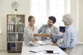 Happy young couple shaking hands with bank manager, real estate agent or mortgage advisor Royalty Free Stock Photo