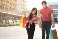 Happy young couple of shoppers walking in the shopping street towards and holding colorful shopping bags in hand. Concept of sale Royalty Free Stock Photo