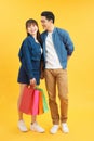 Happy young couple with shopping bags hugging and looking at each other  on yellow Royalty Free Stock Photo