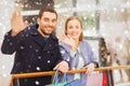 Happy young couple with shopping bags in mall Royalty Free Stock Photo