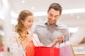 Happy young couple with shopping bags in mall Royalty Free Stock Photo