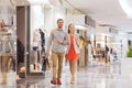 Happy young couple with shopping bags in mall Royalty Free Stock Photo