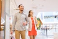 Happy young couple with shopping bags in mall Royalty Free Stock Photo