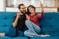 Happy young couple showing peace sign while taking selfie on cellphone Royalty Free Stock Photo