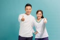 Happy young couple showing thumbs up and looking at camera isolated over blue background Royalty Free Stock Photo