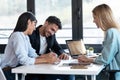 Happy young couple signing bank loan agreement with real-estate agent to buying the house in the office Royalty Free Stock Photo