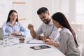 Happy young couple signing purchase contract in real estate agent`s office. Mortgage concept Royalty Free Stock Photo