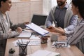 Happy young couple signing purchase contract in real estate agent`s office, closeup. Mortgage concept Royalty Free Stock Photo