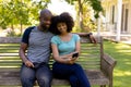 Happy young couple sitting on a bench in the garden Royalty Free Stock Photo