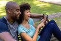 Happy young couple sitting on a bench in the garden Royalty Free Stock Photo