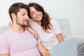 Happy young couple sitting on couch using laptop Royalty Free Stock Photo