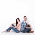 Happy young couple sitting on floor looking up while dreaming their new home and furnishing. Mock up Royalty Free Stock Photo