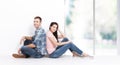 Happy young couple sitting on floor looking up while dreaming their new home and furnishing. Mock up Royalty Free Stock Photo