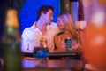 Happy young couple sitting in a nightclub, smiling Royalty Free Stock Photo