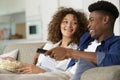happy young couple sitting on sofa watching tv Royalty Free Stock Photo